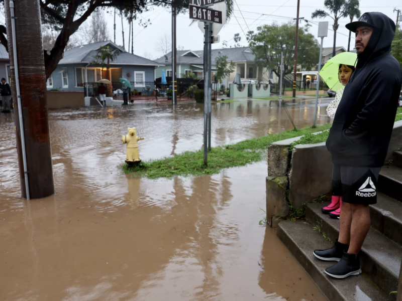 Residents stand along a flooded street in Santa Barbara, California, as a powerful atmospheric river pummels the region. The storm has caused landslides, power outages, and road and airport closures across Southern California. Mario Tama/Getty Images